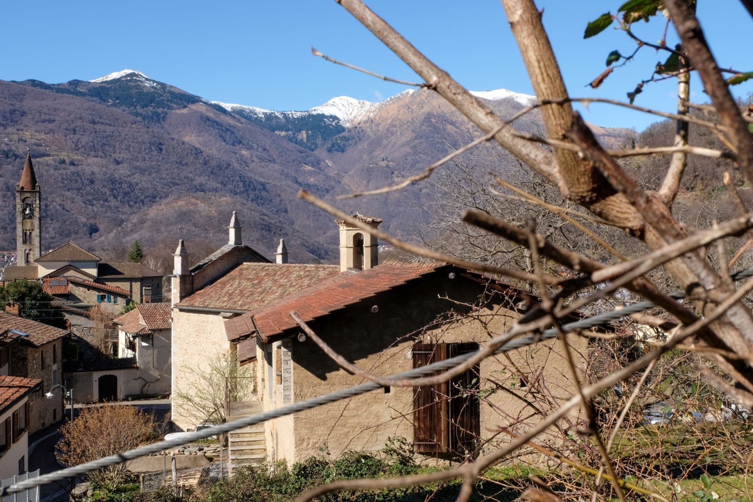 A Vaglio: i boschi della Val Capriasca ancora spogli di foglie e le montagne coperte di neve.