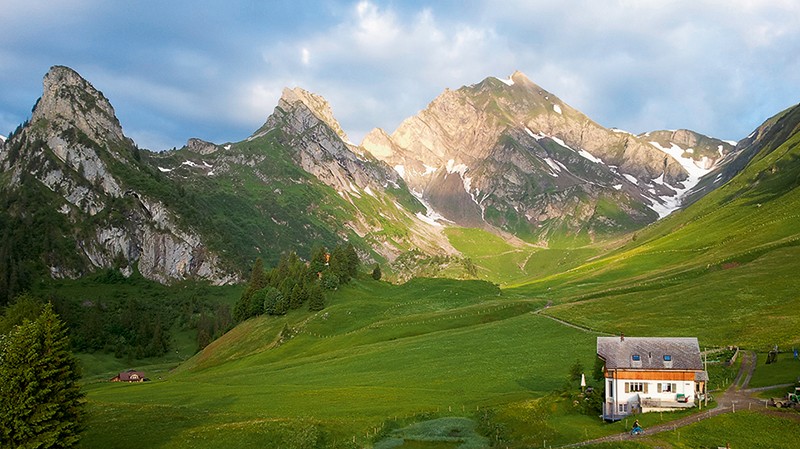 La belle position de la ferme de Kneiwies, sur une terrasse entourée de sommets. A droite, le Hoh Brisen (2413 m)