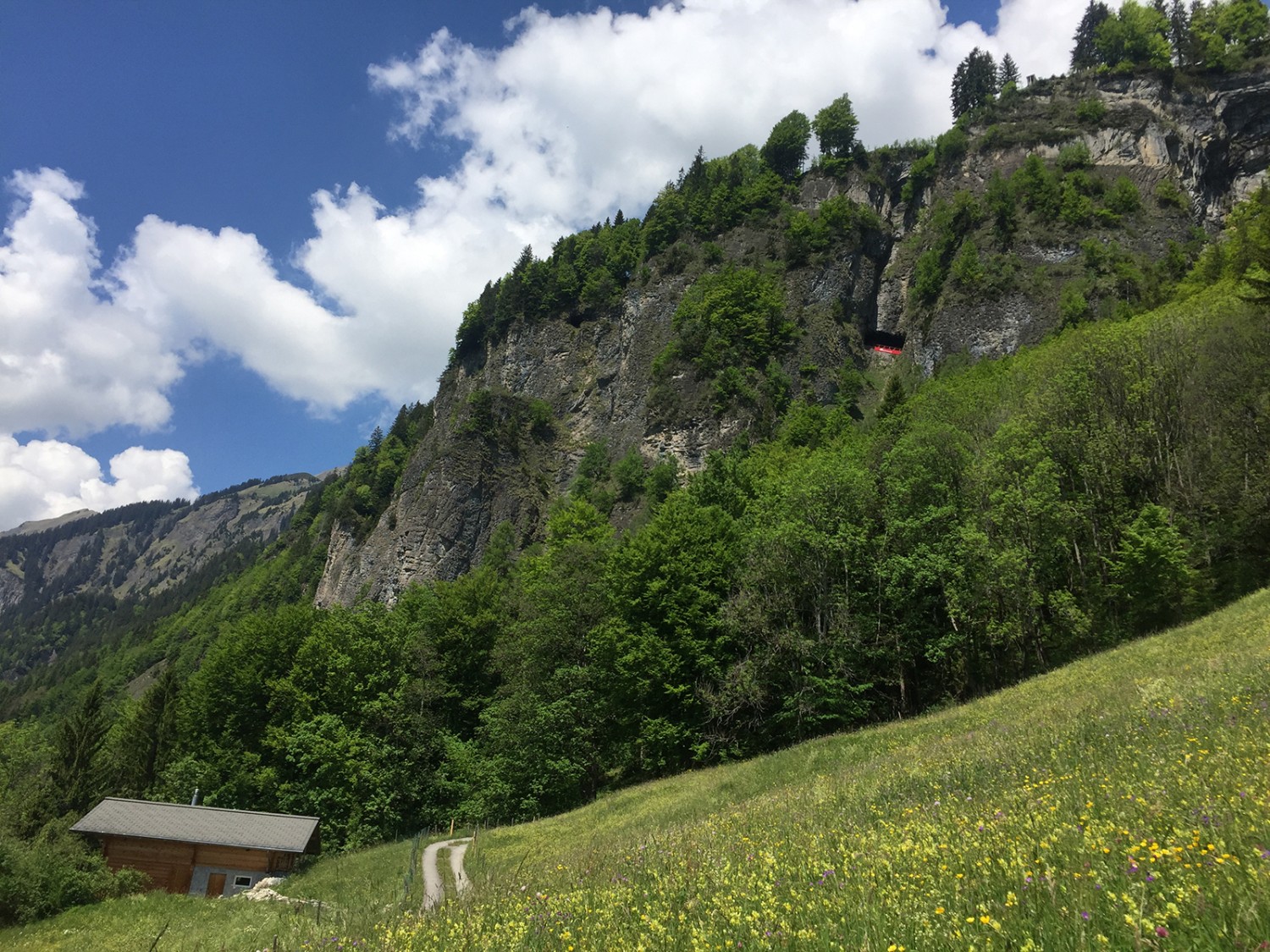 En haut, le train apparaît soudain dans un trou de la roche.