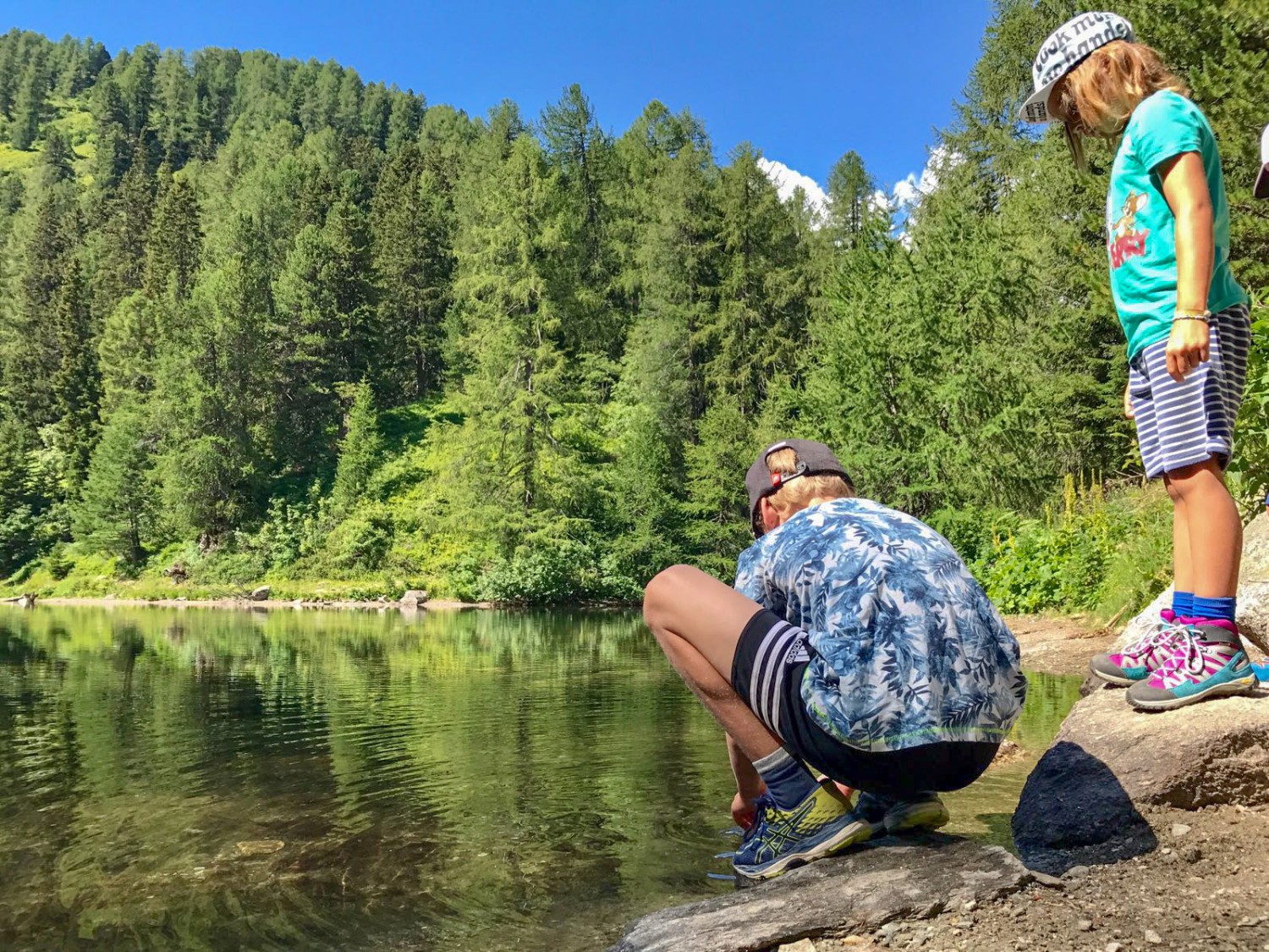 Pause au bord du Lägh da Bitabergh cerclé par une forêt de mélèzes. Photo: Laura Riedi