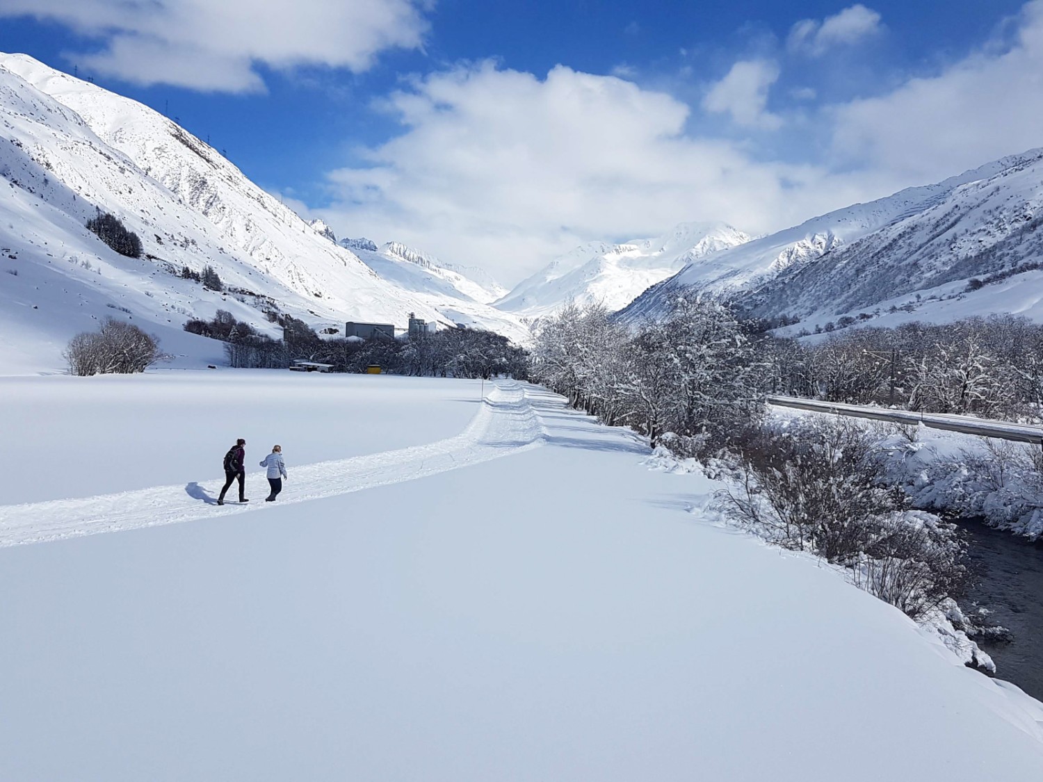 Der Winterwanderweg schlängelt sich durch eine tiefverschneite Berglandschaft. Bild: Laura Riedi